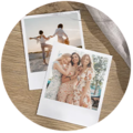 Dwa zdjęcia Polaroid szczęśliwych przyjaciółek, bawiących się razem i śmiejących się, na drewnianym stole.